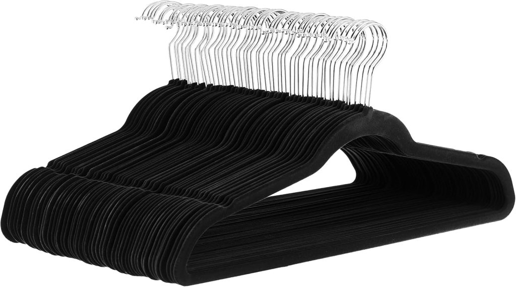 A stack of black velvet hangers with shiny metal hooks, designed for hanging clothes securely.