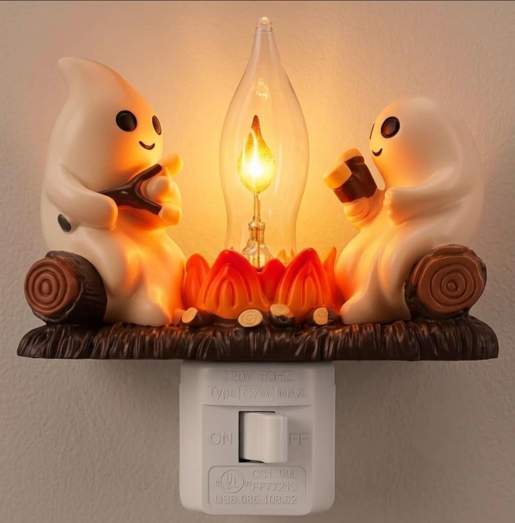 A whimsical night light featuring two friendly ghost figures sitting by a campfire, with a glowing lantern above them.