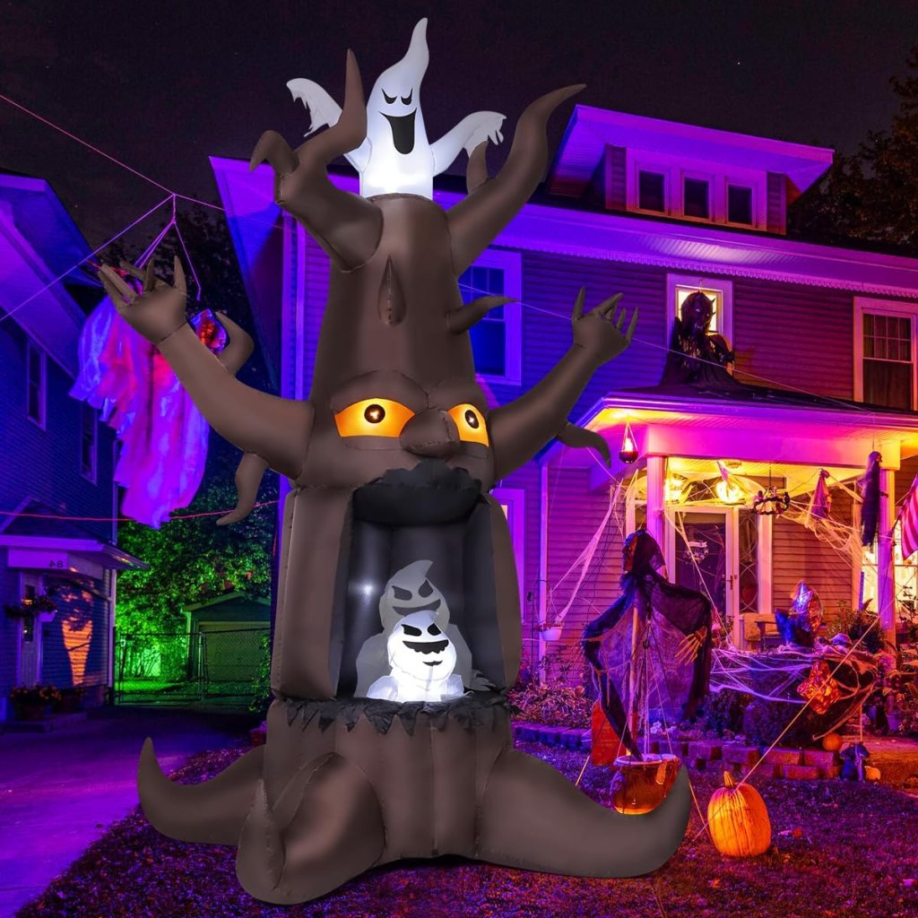 A large inflatable Halloween decoration shaped like a spooky tree with glowing eyes, featuring a ghost at the top and a ghostly figure inside, set against a vividly lit house with Halloween decorations.