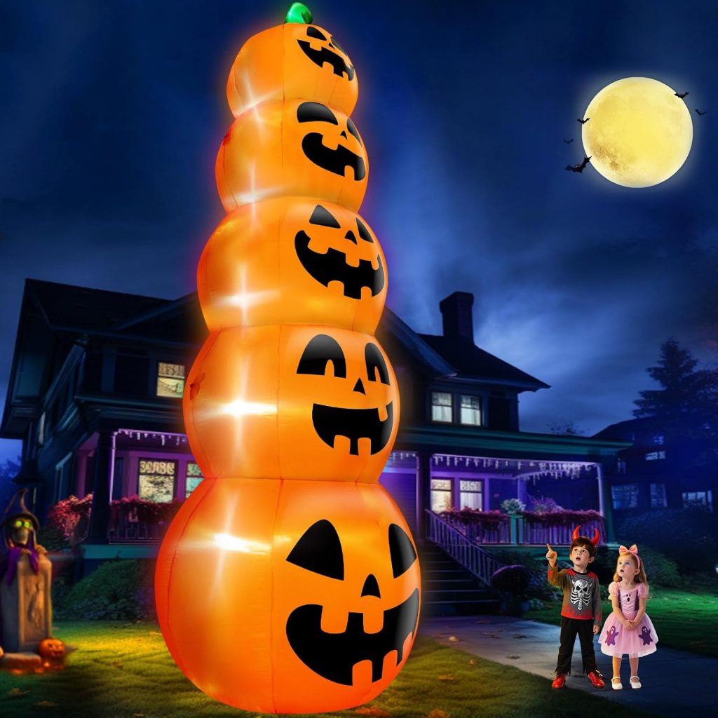 Children admiring a large inflatable Halloween decoration that features stacked, glowing pumpkins with carved faces, set against a nighttime house and moonlit sky.