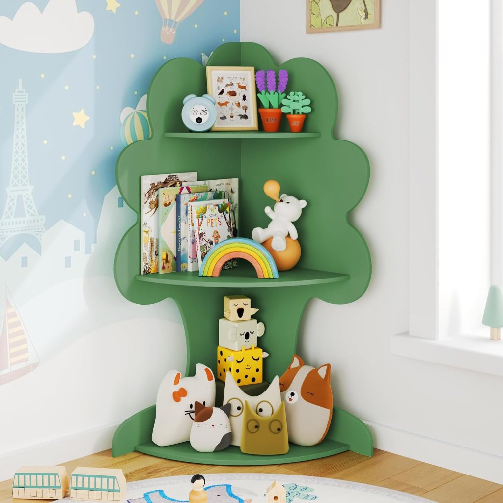 A colorful green bookshelf shaped like a tree, displaying children's books and toys. The top shelf features potted plants, an alarm clock, and framed art, while the lower shelf has a rainbow and various cute animal figurines.