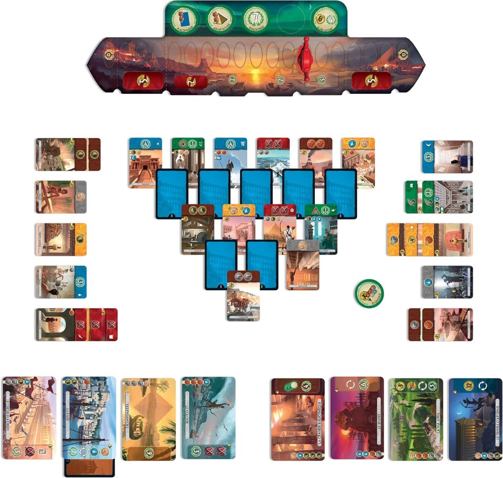 A colorful board game setup featuring various cards, a score track, and player tokens laid out on a table. The game appears to involve strategic decision-making and resource management, with distinct zones for different card types and an organized play area.