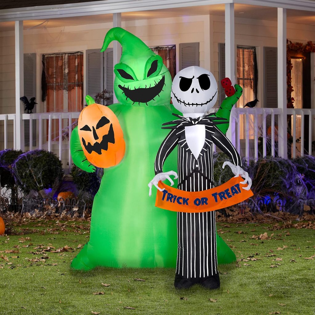 Inflatable Halloween decorations featuring a green monster holding a pumpkin and a character in a black and white striped suit holding a 'Trick or Treat' sign.