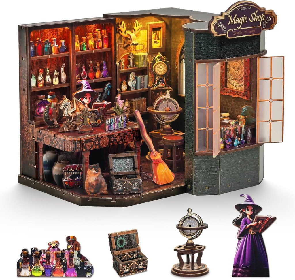 A whimsical magic shop diorama featuring shelves filled with colorful potions, a detailed desk with magical items, a broomstick, and a cat. The exterior includes an open window showcasing more potions and a sign that reads 'Magic Shop'. Various magical artifacts and characters are displayed in the foreground.